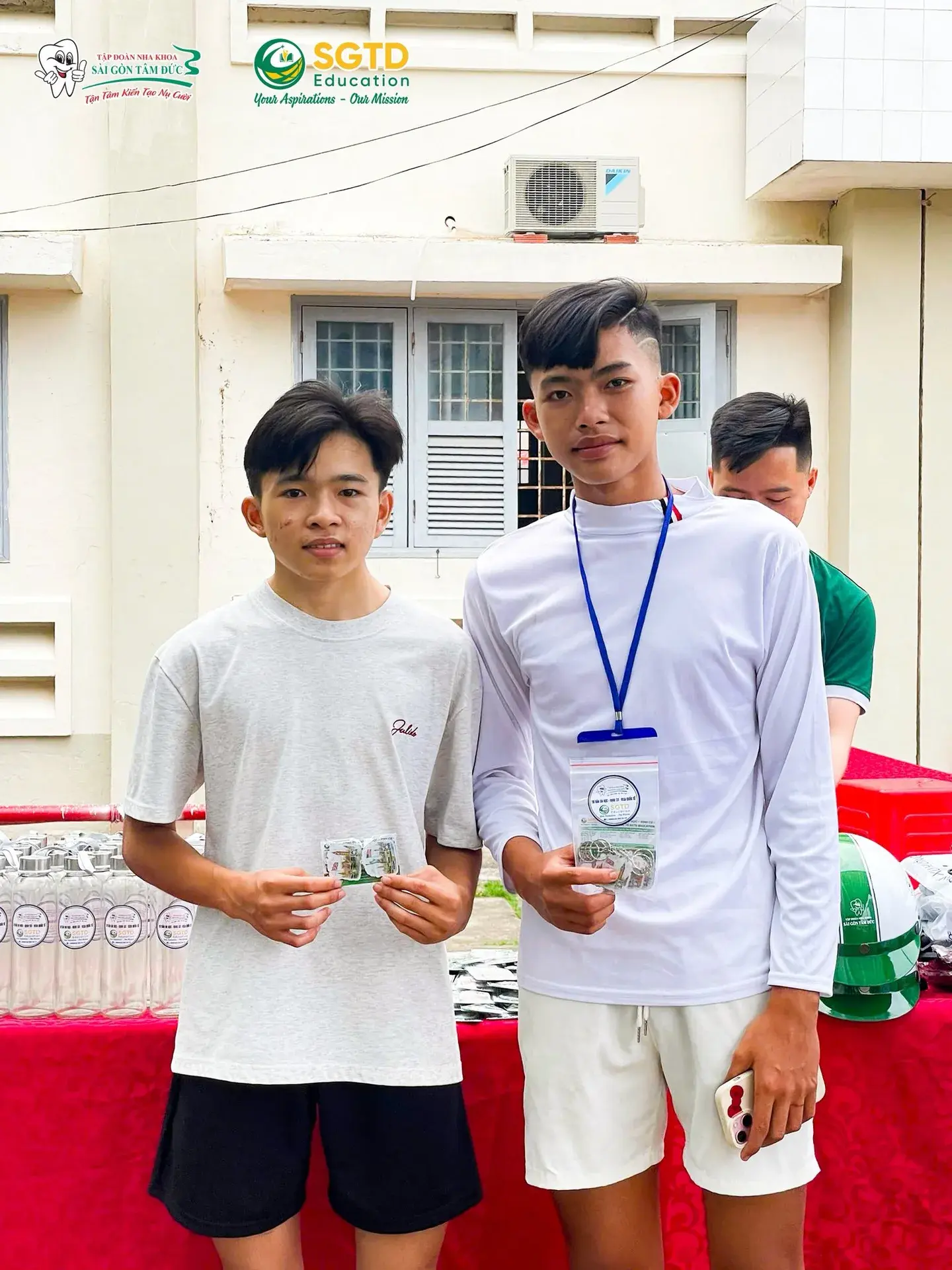 Thầy giáo chụp ảnh cùng banner Ngày Hội Tết Quê – SGTD Education