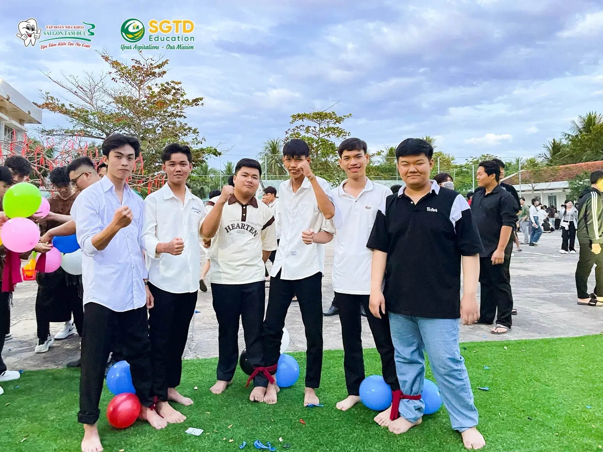 Học sinh mặc trang phục truyền thống chụp ảnh cùng banner SGTD Education